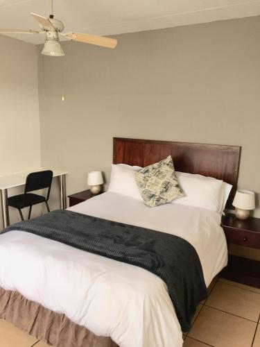 a bedroom with a large bed with a black blanket at African Kingdom Guest House in Boksburg