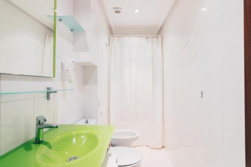 baño con lavabo verde y aseo en Apple by People Rentals, en San Sebastián