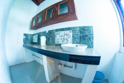 La salle de bains est pourvue d'un comptoir et d'un lavabo. dans l'établissement Shadow Surf Bay, à Tangalle