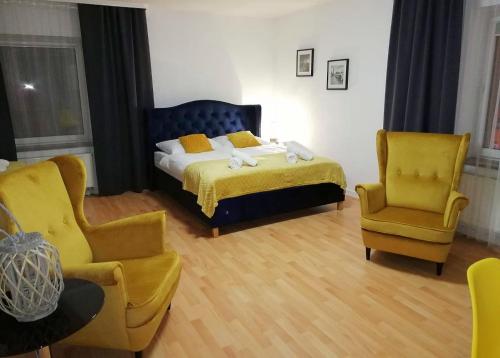 1 dormitorio con 1 cama y 2 sillas en Great Polonia Strzegom City Center, en Strzegom