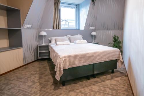 a bedroom with a bed with two pillows and a window at Golden Zaan Hotel, Zaandam-Amsterdam in Zaandam