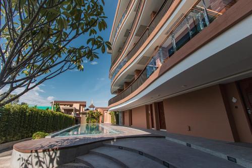 a building with a swimming pool next to a building at Rachabhura Hotel in Ratchaburi