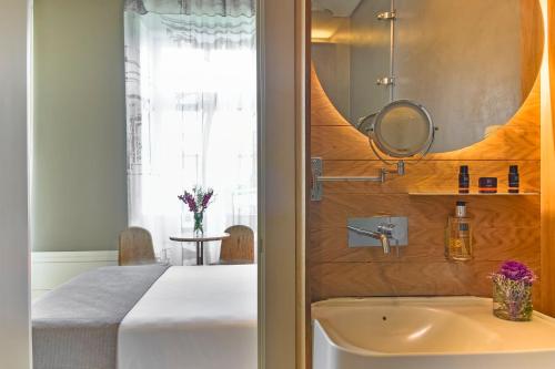 a bathroom with a bed and a sink and a mirror at My Story Hotel Rossio in Lisbon
