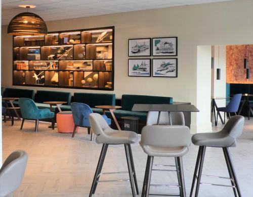 a waiting area with chairs and tables in a waiting room at Mercure Bedford Centre Hotel in Bedford