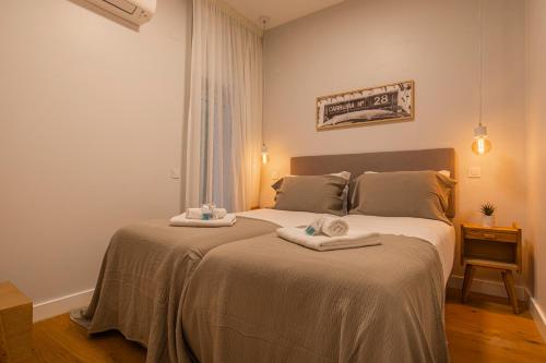 ein Schlafzimmer mit 2 Betten und Handtüchern darauf in der Unterkunft Upscale & Modern 2BDR Apartment in Lissabon