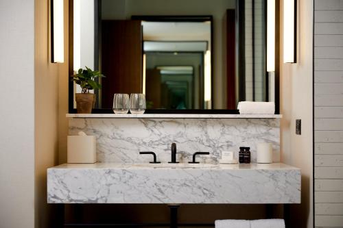 a bathroom with a white marble sink with a mirror at Hotel Haya in Tampa