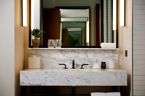 een badkamer met een witte marmeren wastafel en een spiegel bij Hotel Haya in Tampa
