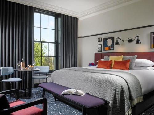 um quarto com uma cama grande, uma mesa e cadeiras em The Mont em Dublin