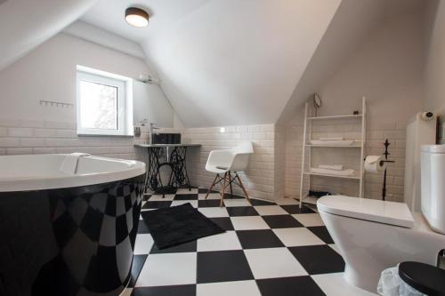 a bathroom with a black and white checkered floor at Villa Adam in Pieszyce