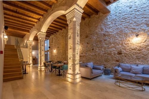 a living room with couches and a stone wall at Casa Dei Delfini in Rethymno