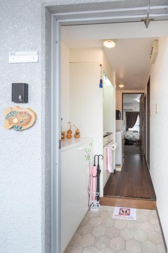 a hallway leading into a kitchen with a door open at Cozy house 402 free wifi a rented electric bicycle in Kyoto