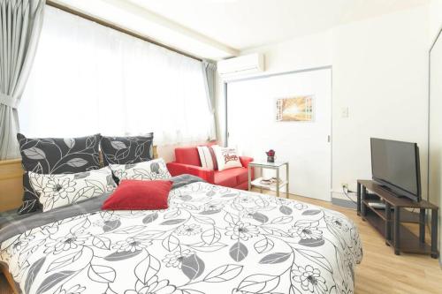 a bedroom with a black and white bed and a tv at ESPERANZA103 広い綺麗快適高速WiFi in Tokyo