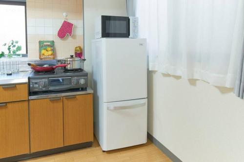 a white refrigerator with a microwave on top of it at ESPERANZA103 広い綺麗快適高速WiFi in Tokyo