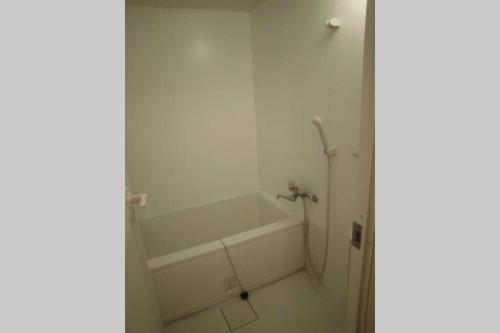 a white bathroom with a bath tub in a room at ESPERANZA103 広い綺麗快適高速WiFi in Tokyo