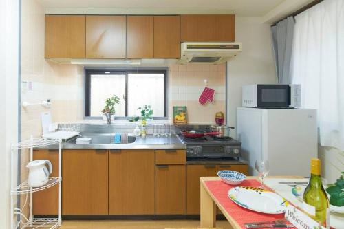 a kitchen with wooden cabinets and a white refrigerator at ESPERANZA103 広い綺麗快適高速WiFi in Tokyo