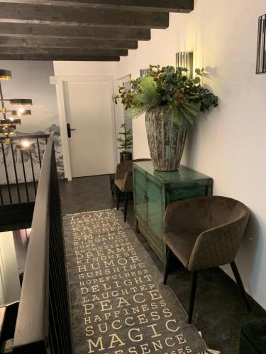 a living room with a vase on a dresser with a chair at Chalet Mirandum Apartments Vandans in Vandans
