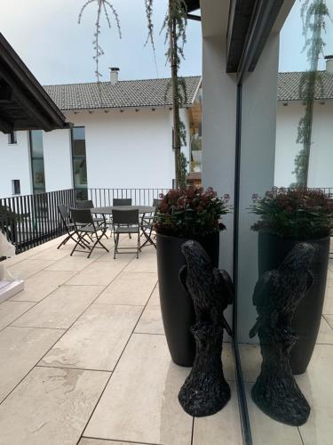 two black vases with plants in them on a patio at Chalet Mirandum Apartments Vandans in Vandans