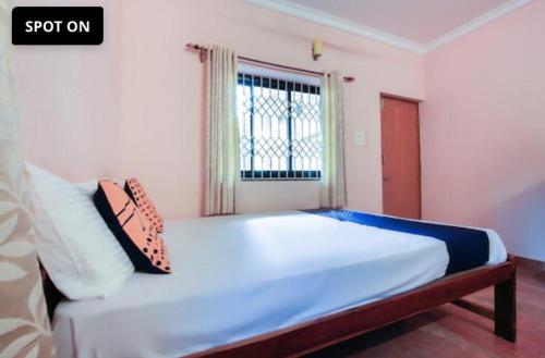 a bedroom with a large white bed with a window at Gods gift guesthouse in Arambol