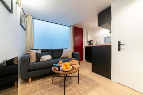 un salon avec un canapé et une table dans l'établissement Architect's Duplex - Haut Marais, à Paris