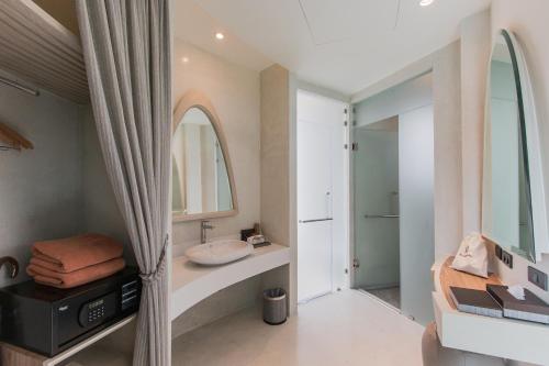 a bathroom with a sink and a mirror at Rachabhura Hotel in Ratchaburi