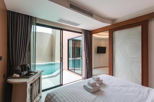 a bedroom with a bed and a view of a pool at Rachabhura Hotel in Ratchaburi