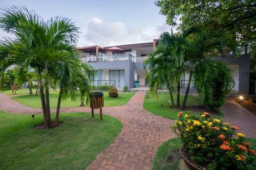 インバサイにあるSolaris Villageの椰子の木と煉瓦の通路のある建物