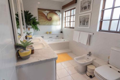 ein weißes Bad mit einem Waschbecken und einem WC in der Unterkunft 15 Oyster Crescent in Durban