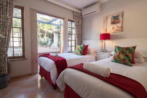 2 Betten in einem Zimmer mit 2 Fenstern in der Unterkunft 15 Oyster Crescent in Durban