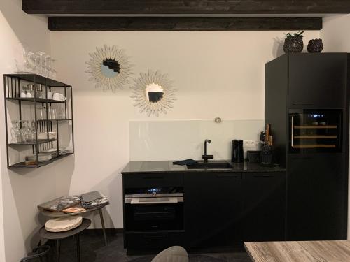 a kitchen with a black refrigerator and a sink at Chalet Mirandum Apartments Vandans in Vandans