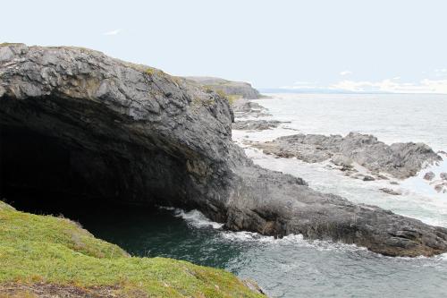 a cave on the side of a rocky beach at Burnt Cape Cabins in Raleigh