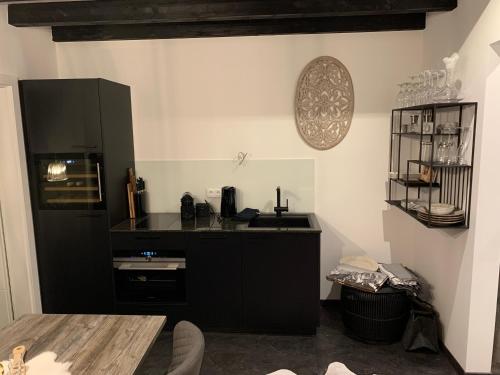 a kitchen with a sink and a black refrigerator at Chalet Mirandum Apartments Vandans in Vandans
