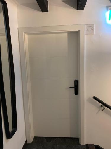 a white door in a room with a mirror at Chalet Mirandum Apartments Vandans in Vandans
