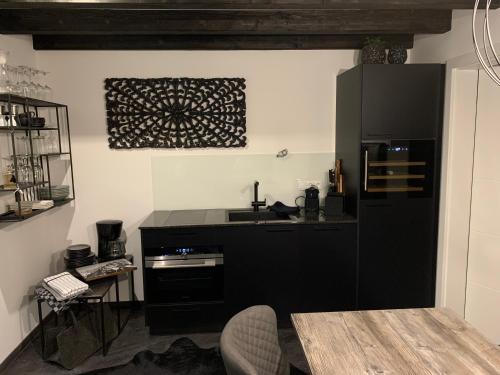 a kitchen with a black refrigerator and a table at Chalet Mirandum Apartments Vandans in Vandans