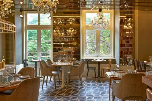 a dining room with tables and chairs and windows at My Story Hotel Rossio in Lisbon