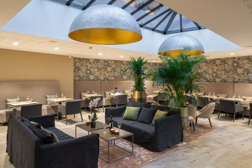 een eetkamer met tafels en banken en een eettafel bij Edgar Hôtel & Spa - Table Gastronomique in Saint-Brieuc