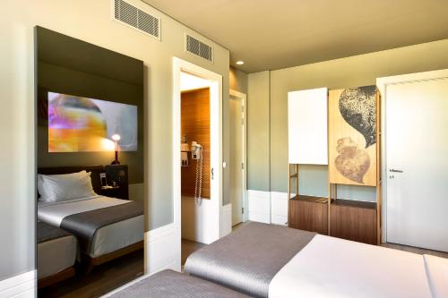 - une chambre avec 2 lits et une porte menant à une pièce dans l'établissement My Story Hotel Rossio, à Lisbonne