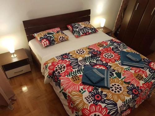 Un dormitorio con una cama grande con una colcha floral. en Apartman Jovanka 2, en Trebinje
