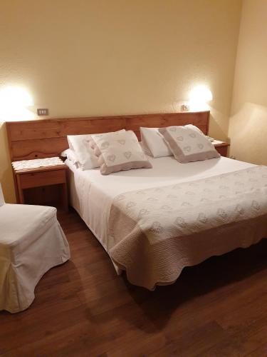 a bedroom with a large bed with white sheets and pillows at Centrale in Courmayeur
