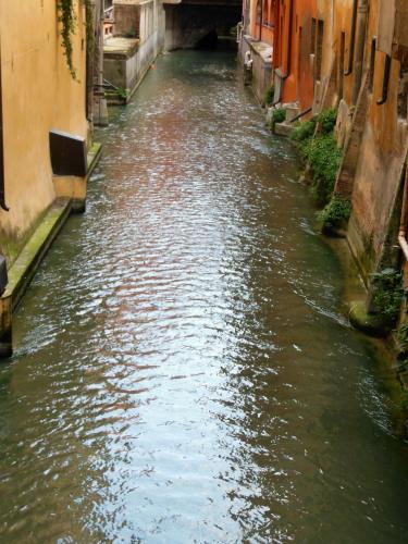 a canal between two buildings in a city at Hotel San Giorgio in Bologna