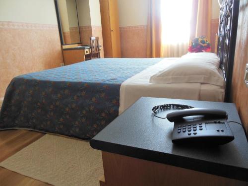 a room with a phone on a table next to a bed at Hotel San Giorgio in Bologna