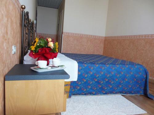 a hotel room with a bed with a tray of flowers at Hotel San Giorgio in Bologna