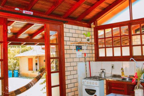 a kitchen with a stove and an open window at Morada Quatro Elementos in Praia do Rosa