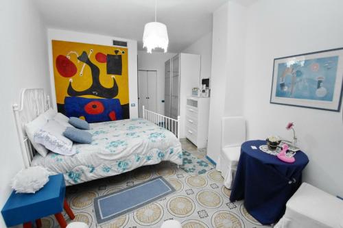 a small bedroom with a bed and a table at I Love Art in Cagliari
