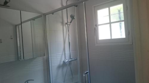 een badkamer met een douche, een raam en een glazen deur bij la Pequenita in Saint-Raphaël