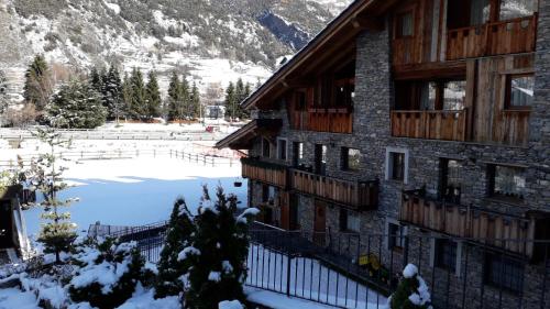 a building in the snow with a pond in front at Il Cuore della Valdigne - Courmayeur-La Thuile- Pré Saint Didier in Morgex