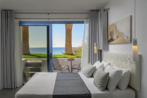 a bedroom with a bed and a view of the ocean at White Pearl in Makry Gialos