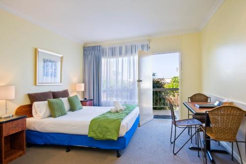 a bedroom with a large bed and a desk and a desk at The Sandridge Motel in Lorne