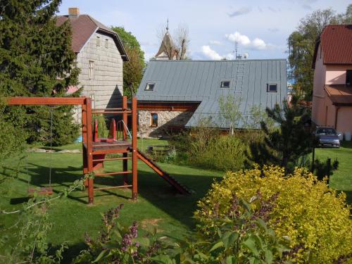 a playground in the middle of a yard with a barn at Apartmány Nové Hutě in Nové Hutě