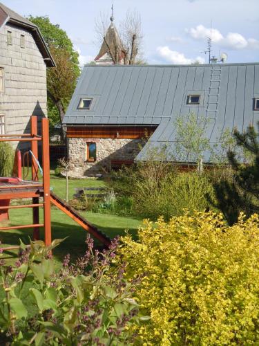 a house with a metal roof and a playground at Apartmány Nové Hutě in Nové Hutě