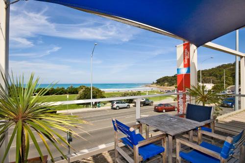 a table and chairs on a balcony with a view of the ocean at The Sandridge Motel in Lorne